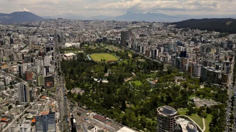 Vista urbana de Quito con edificios y un parque central.